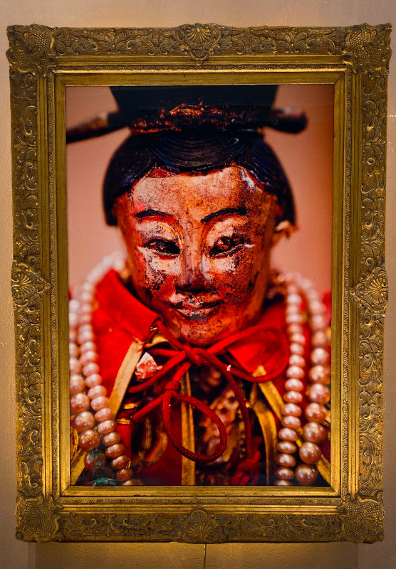 A framed and colored illustration of a female figure dressed in a red and gold outfit with a vintage wooden frame, presented as a collectible item.
