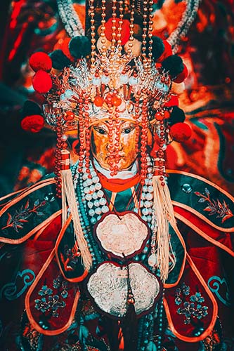 A glossy metal print featuring a colorful depiction of the sea goddess Tin Hau with a wooden recycled frame.
