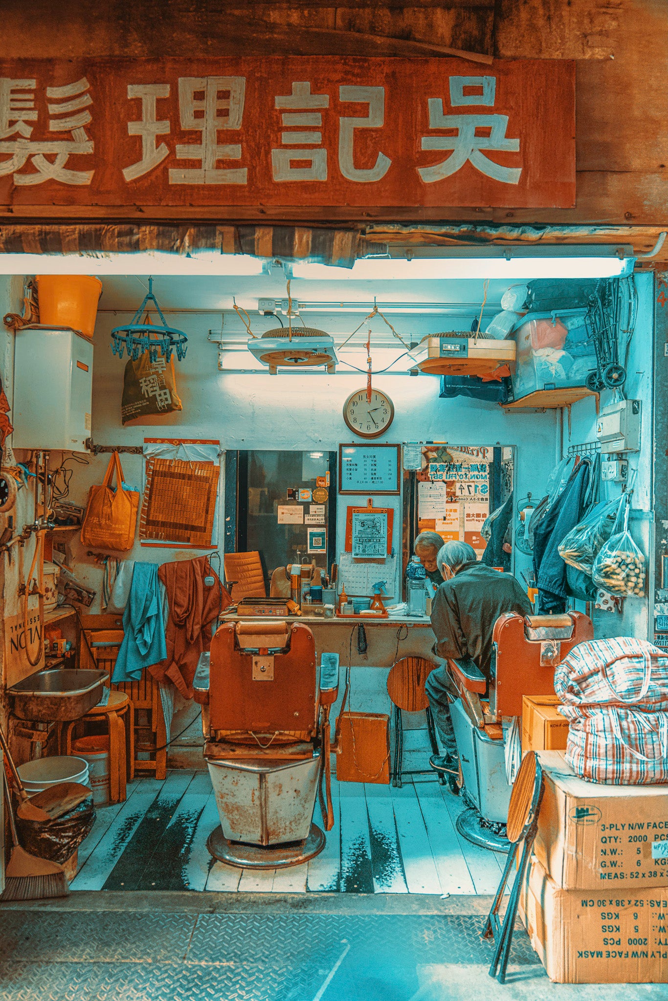 an interior view of a traditional roadside hair salon in Hong Kong, with hand-painted signage, fans, and many other details...
